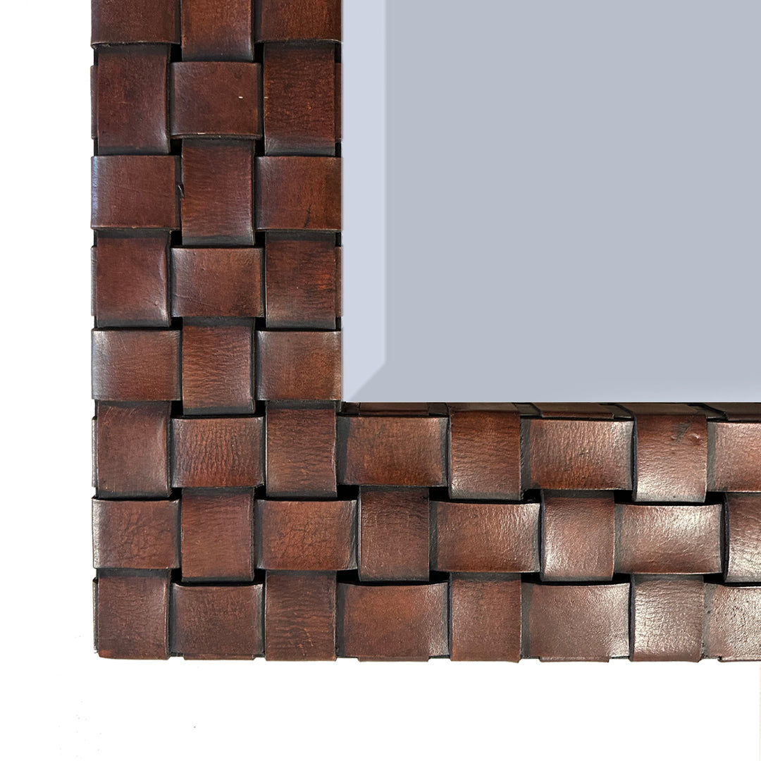 Corner detail of woven leather mirror on white background