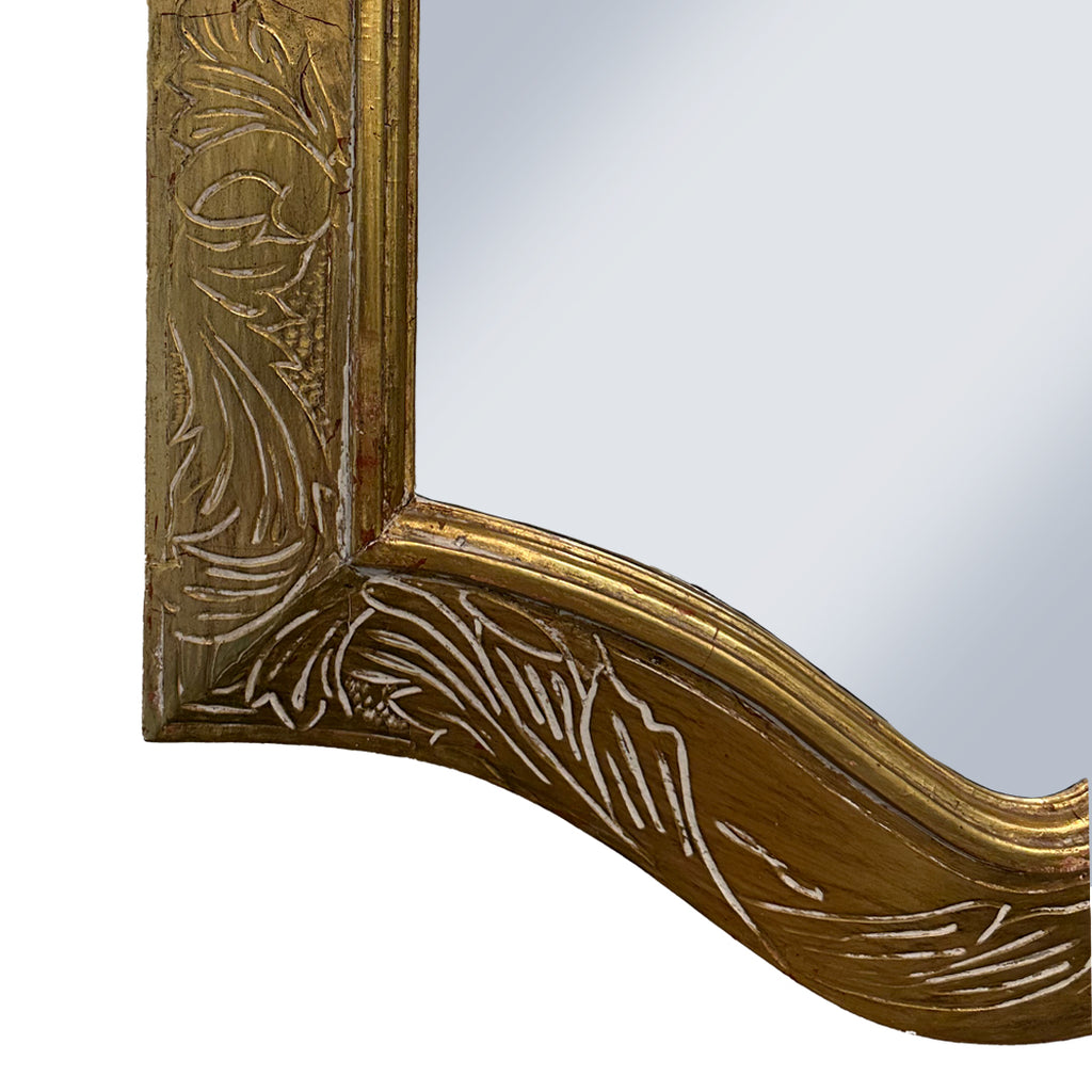 Corner detail of Decorative gold mirror frame with intricate patterns on a white background