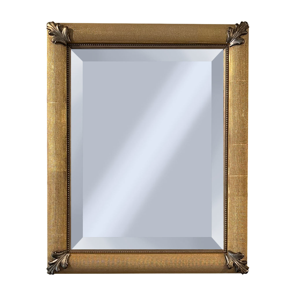 Decorative mirror with silver corner decor on a gold frame on a white background