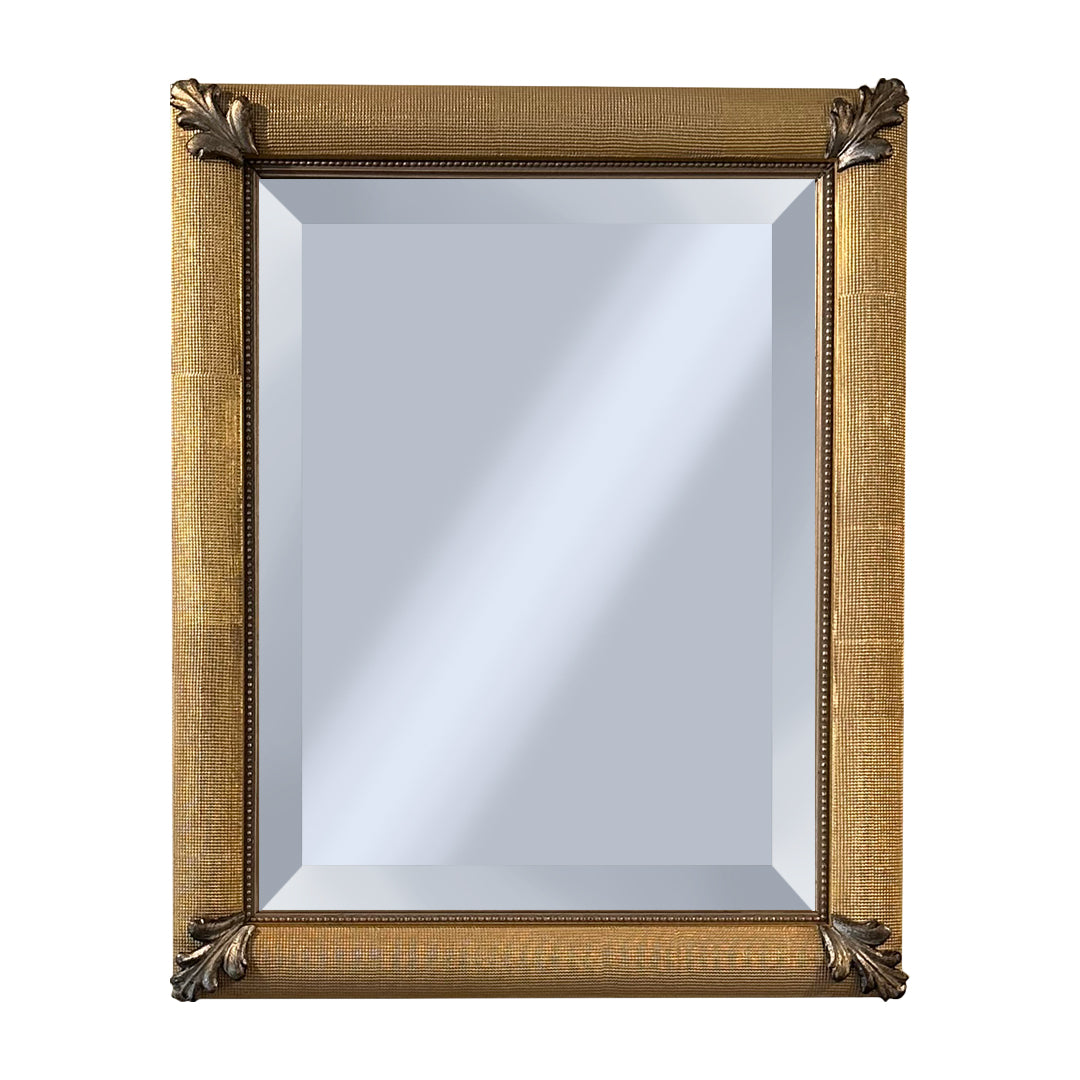 Decorative mirror with silver corner decor on a gold frame on a white background