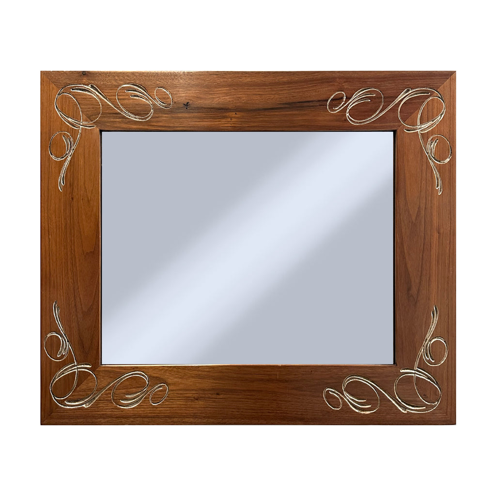 Wooden mirror with decorative silver carvings on a white background